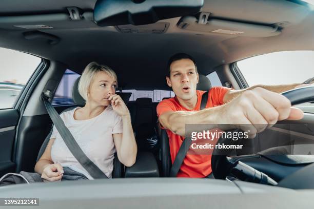 front portrait of young couple driving car on high speed. delighted driver after buying a new vehicle - man driving anxiously stock-fotos und bilder