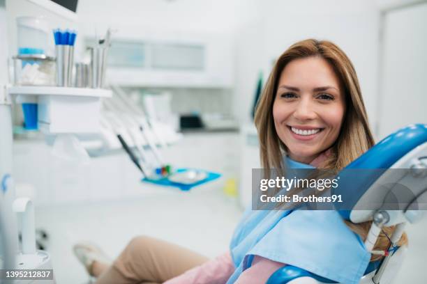 glückliche frau, die eine zahnarztpraxis besucht - zahnarzt stock-fotos und bilder
