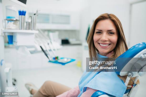 mujer feliz visitando un consultorio odontológico - dentist's office fotografías e imágenes de stock