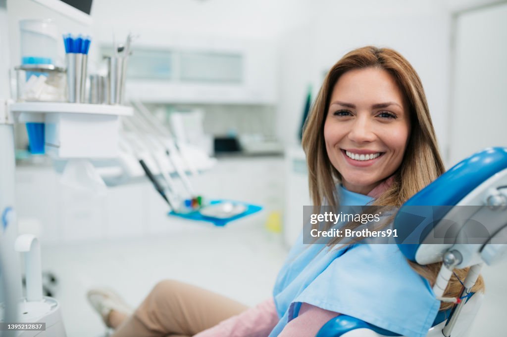 Mulher feliz visitando um consultório dentista