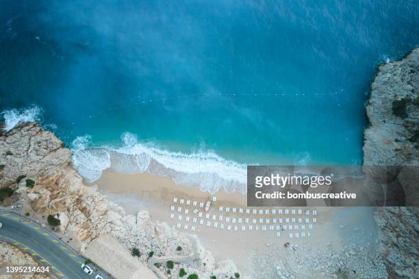 top-down aerial view of a white sandy beach on the shores of a beautiful turquoise sea - boat top view stock pictures, royalty-free photos & images