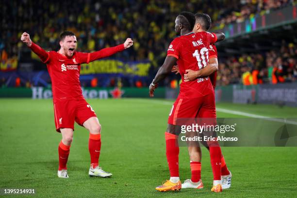 Sadio Mane celebrates with teammates Thiago Alcantara and Andrew Robertson of Liverpool after scoring their team's third goal during the UEFA...