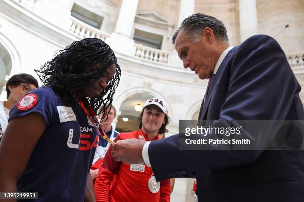 Sen. Mitt Romney looks at the gold medal of Team USA Olympic speed skater Erin Jackson as he greets with her and other Team USA athletes at the U.S....