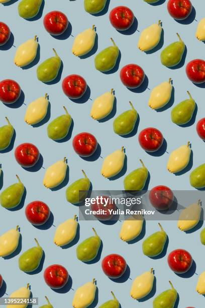 repeated pears and apples on the blue background - apple pattern stock-fotos und bilder