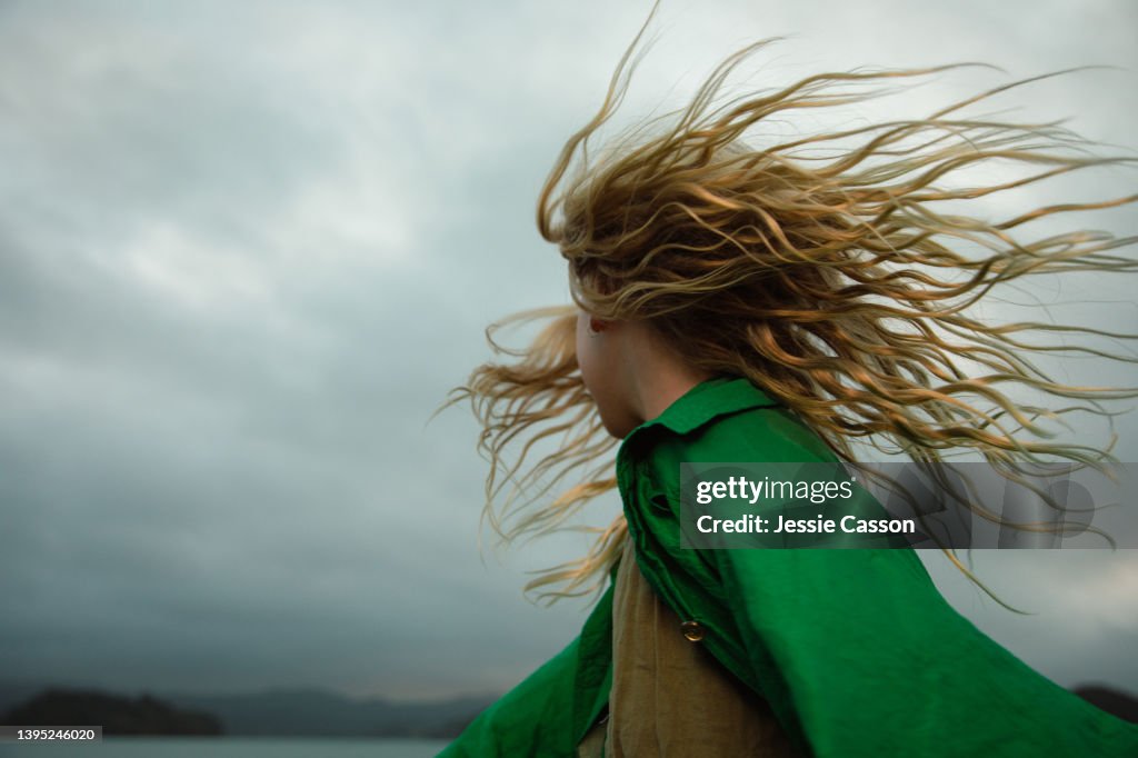 A girl dancing with wild hair in moody light