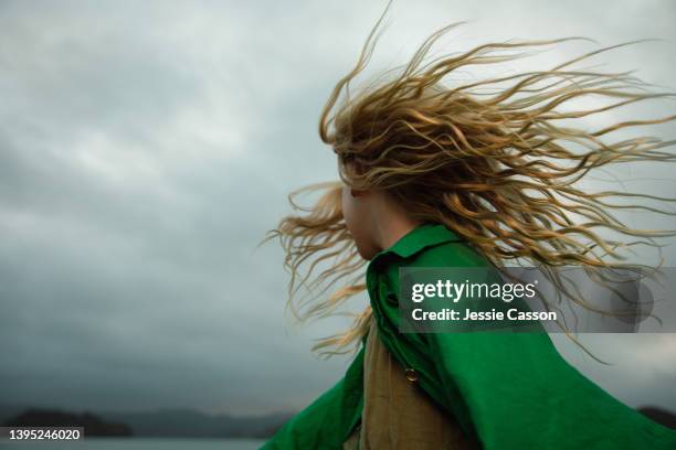 a girl dancing with wild hair in moody light - wind fotografías e imágenes de stock