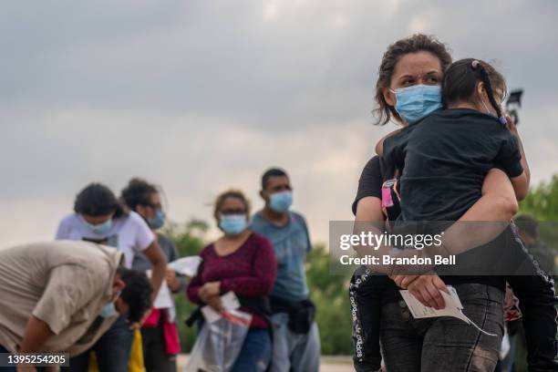 El Salvadorian migrants Yesenia Martinez and her daughter Jaretzy wait alongside other migrants to be processed after crossing the Rio Grande into...