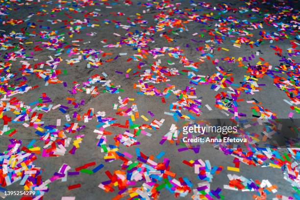 many multi colored confetti on concrete floor after party. concept of celebration event ending - draft after party stock-fotos und bilder