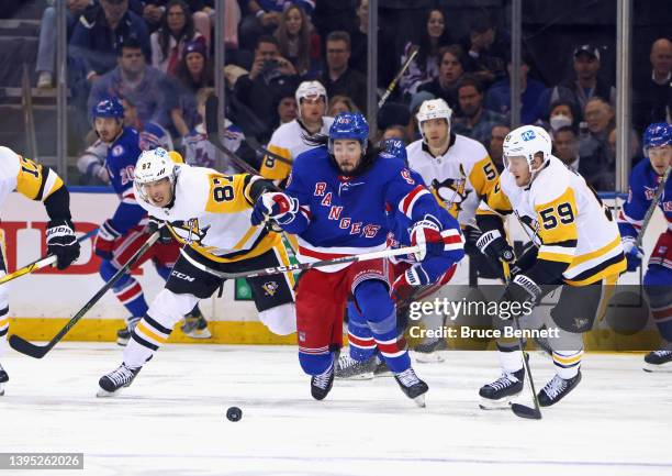 Sidney Crosby and Jake Guentzel of the Pittsburgh Penguins defend against Mika Zibanejad of the New York Rangers during the third period in Game One...