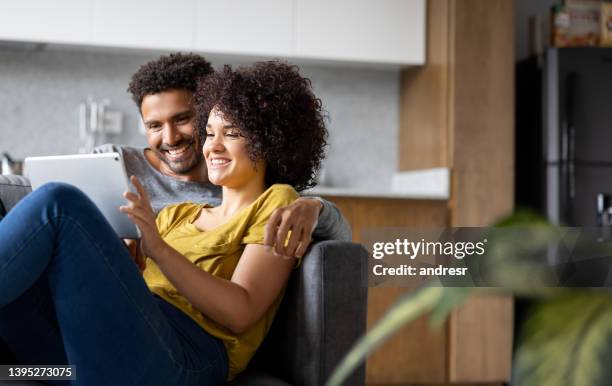 feliz pareja relajándose en casa viendo una película en línea - home movie fotografías e imágenes de stock