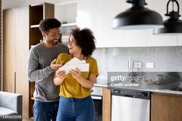 happy couple reading a letter in the mail and looking very excited - couple in surprise stock pictures, royalty-free photos & images