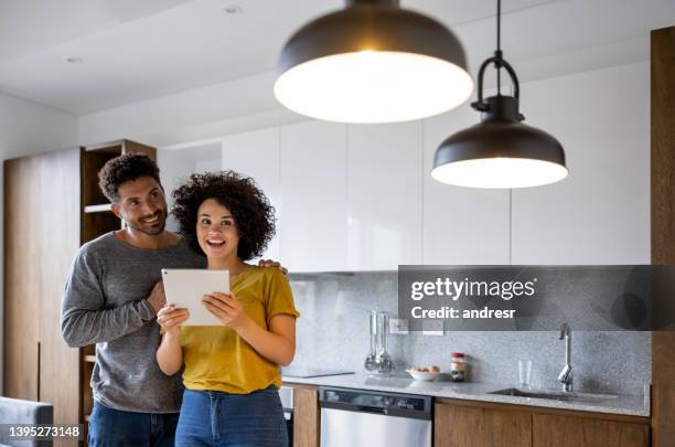 couple controlling the lights in their house using an automation system - domotic stockfoto's en -beelden