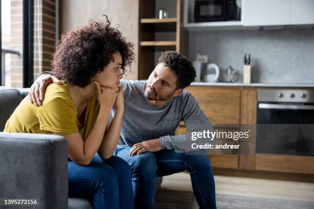 man comforting his girlfriend at home - apologize imagens e fotografias de stock