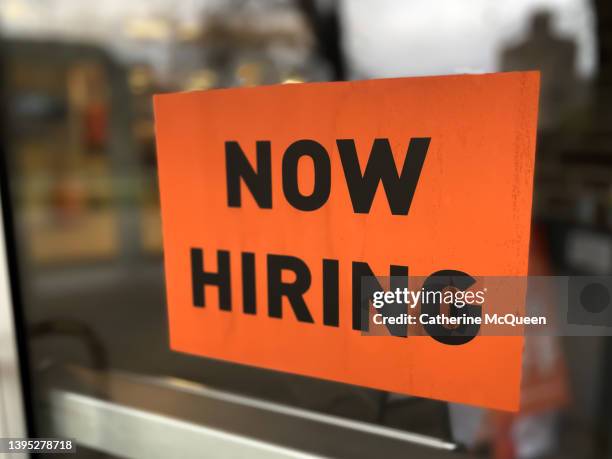 “now hiring” sign posted on business door - wanted stockfoto's en -beelden