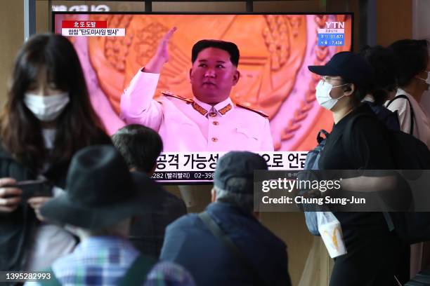 People watch a television broadcast showing a file image of North Korean leader Kim Jong-Un during a military parade at the Seoul Railway Station on...