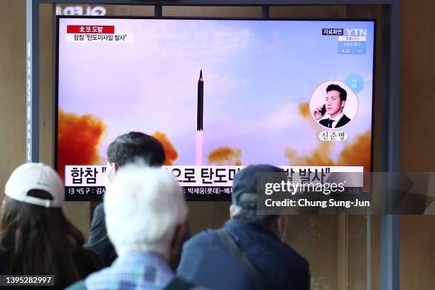 People watch a television broadcast showing a file image of a North Korean missile launch at the Seoul Railway Station on May 04, 2022 in Seoul,...