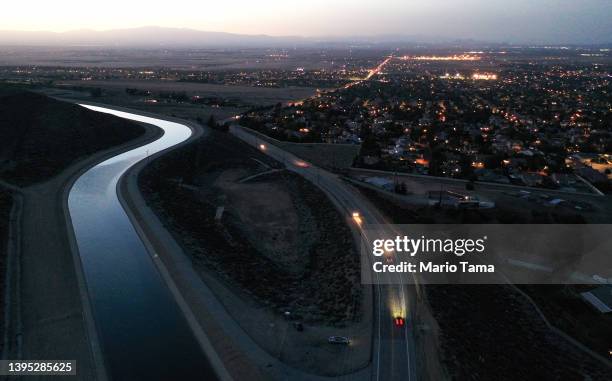 An aerial view of the California Aqueduct , which moves water from northern California to the state's drier south, as cars pass below on May 3, 2022...