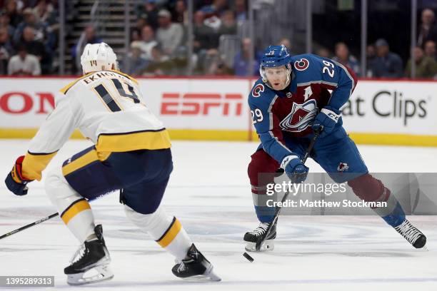 Nathan MacKinnon of the Colorado Avalanche advances the puck against Mattias Ekholm of the Nashville Predators in the second period during Game One...