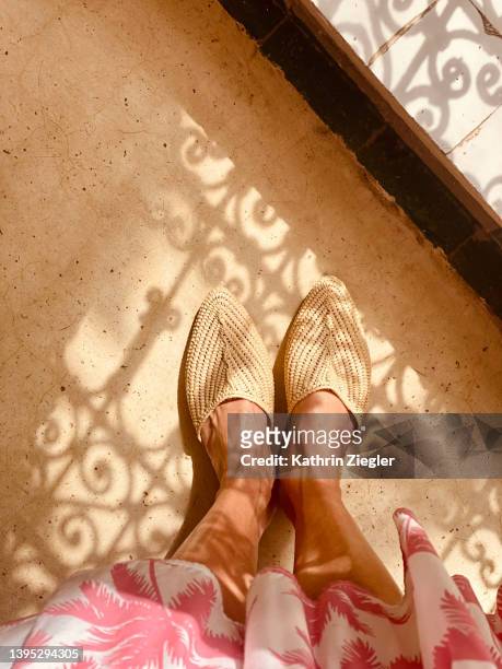 woman wearing beautiful handmade moroccan slippers, personal perspective - cream colored shoe stock-fotos und bilder