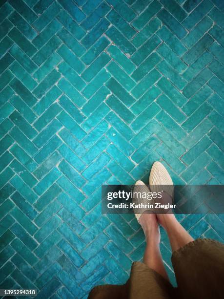 woman standing on beautiful tiled floor, personal perspective - blue shoe stock-fotos und bilder