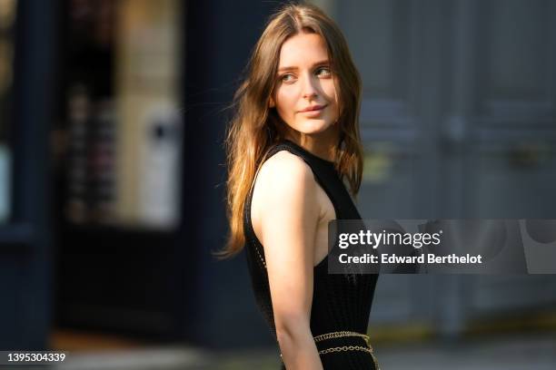 Diane Batoukina wears black sunglasses, a black V-neck / tank-top short tube dress, a black mesh sleeveless long tube dress from Massimo Dutti, a...