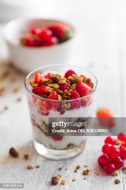 granola and yogurt in a jar with raspberries strawberries and currants - ティラミス　ガラス ストックフォトと画像