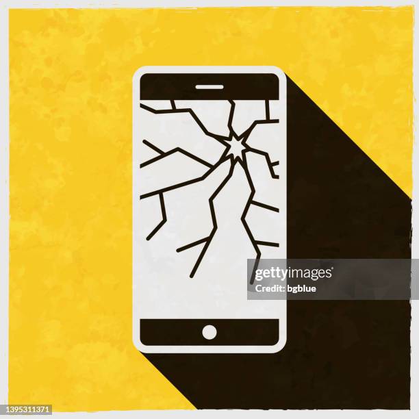 smartphone with broken screen. icon with long shadow on textured yellow background - outdated smartphone stock illustrations