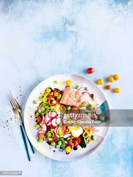 plate of fresh salad with fried salmon on blue background - gegrillter lachs stock-fotos und bilder
