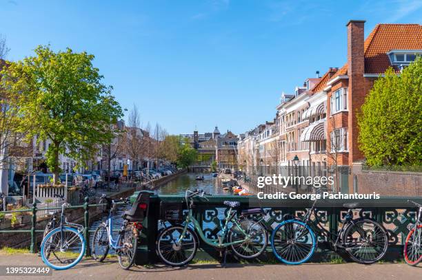 bicycles parked next to the canal in the center of the hague, holland - la haye stock pictures, royalty-free photos & images