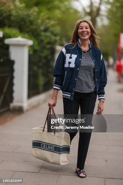 Yasmin von Schlieffen-Nannen seen wearing a dark blue velour college jacket from Halfboy, a black and white striped shirt from Saint Laurent, a black...