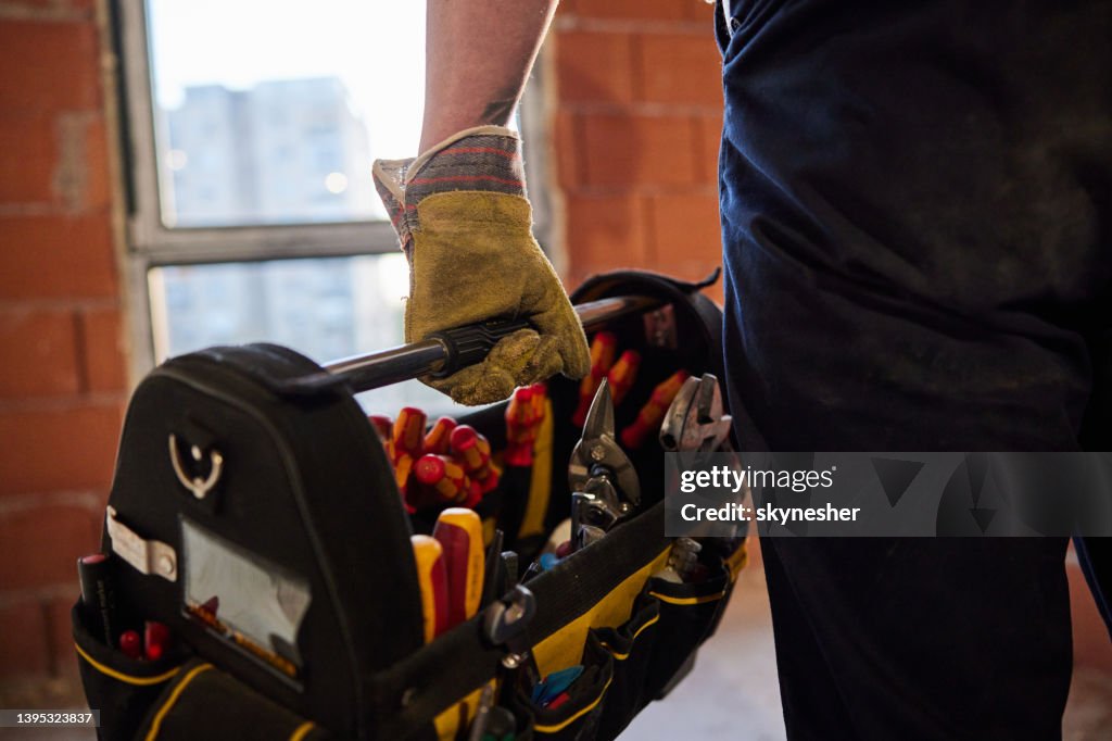 Close up of unrecognizable manual worker carrying toolbox.