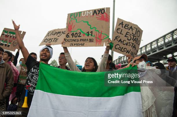 Demonstrators hold signs in support to the victims of the Puerto Leguizamo, Putumayo military raid, during the 28 of April commemorative...