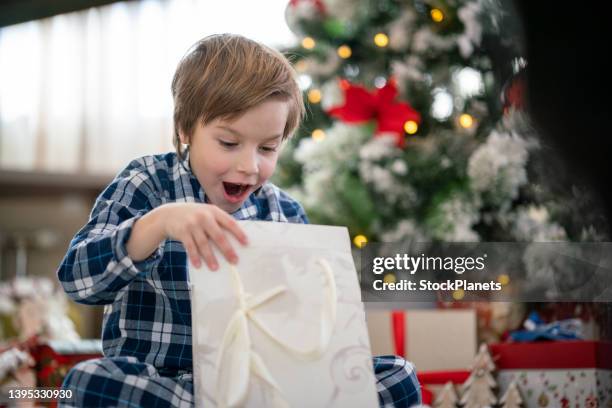 boy opening christmas present - december 6 stock pictures, royalty-free photos & images