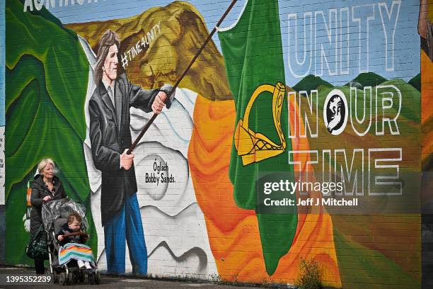 Members of the public walk past a mural on the Falls Road ahead of voters going to the polls on Thursday on May 4, 2022 in Belfast,Northern Ireland....