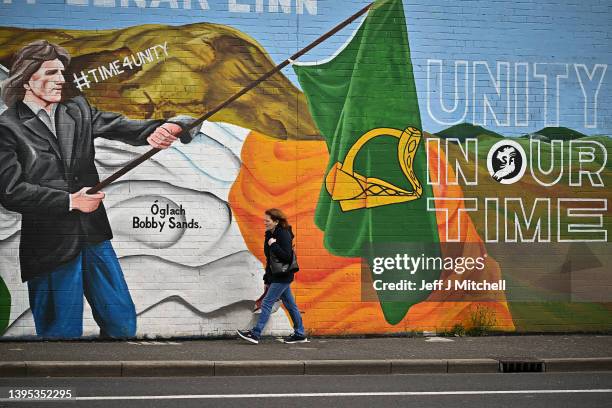 Members of the public walk past a mural on the Falls Road ahead of voters going to the polls on Thursday on May 4, 2022 in Belfast,Northern Ireland....