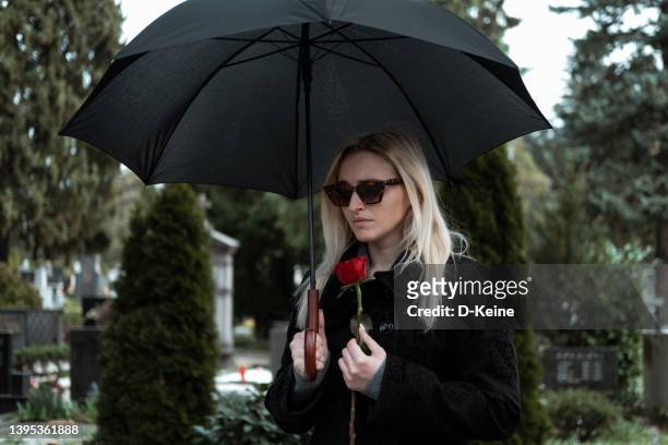cemetery - white and black women and umbrella stockfoto's en -beelden