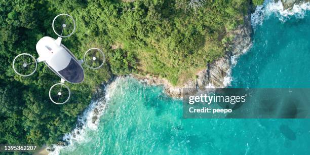 evtol electric vertical take off and landing aircraft flying over coastal location - low carbon technology stockfoto's en -beelden