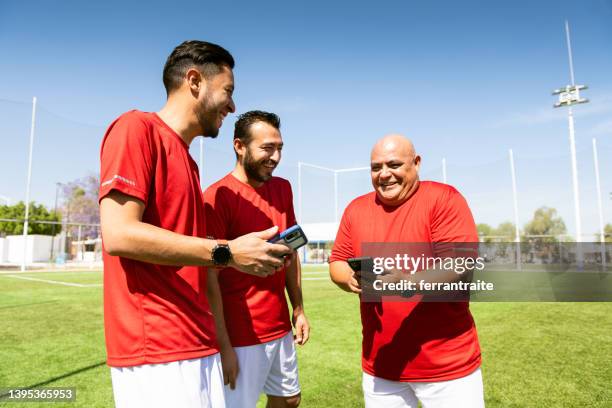 soccer team mates using phone - fat soccer players stock pictures, royalty-free photos & images