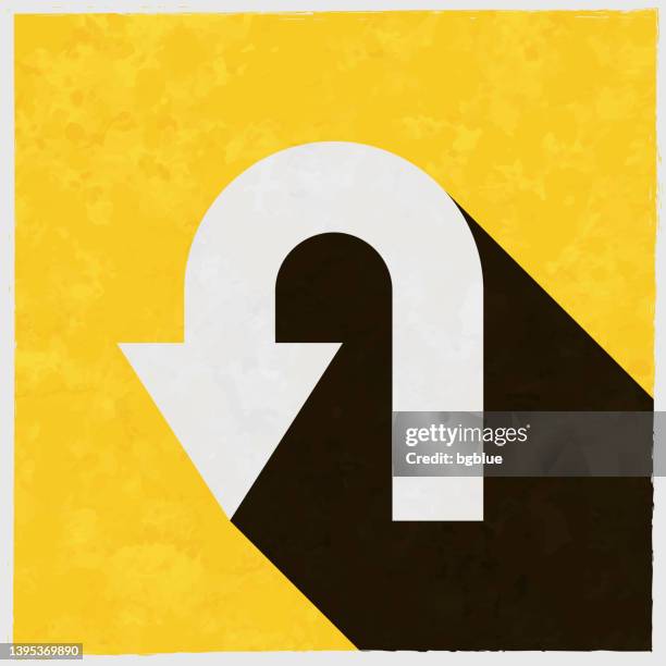 u-turn direction arrow. icon with long shadow on textured yellow background - reversing stock illustrations