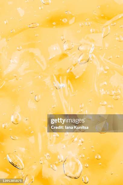 transparent yellow smudged texture. vitamin c. facial serum. antibacterial gel with bubbles. cosmetic products for skincare. vertical pattern. - beverage with cream stockfoto's en -beelden