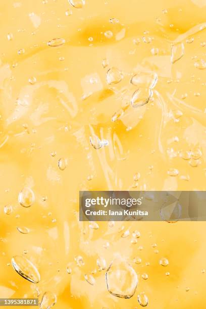 transparent yellow smudged texture. vitamin c. facial serum. antibacterial gel with bubbles. cosmetic products for skincare. vertical pattern. - citrus fruit background stock pictures, royalty-free photos & images