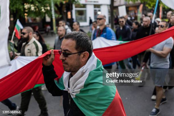 Man holds a Bulgarian flag as he attend a protest against military support for Ukraine on May 4, 2022 in Varna, Bulgaria. Bulgaria's parliament voted...