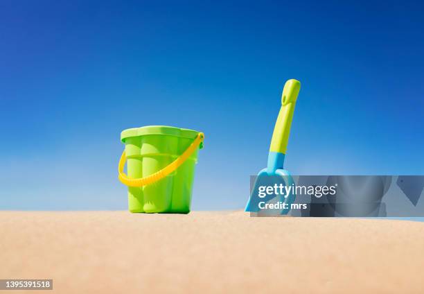 pail and shovel in sand - beach bucket stock pictures, royalty-free photos & images
