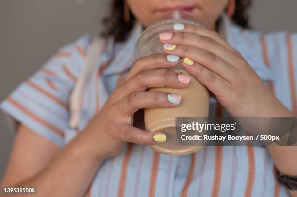 close up shot of woman with pastel painted nails - pastel colored stock-fotos und bilder