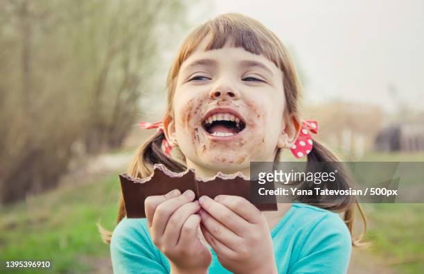 a sweet-toothed child eats chocolate selective focus - usar la boca fotografías e imágenes de stock