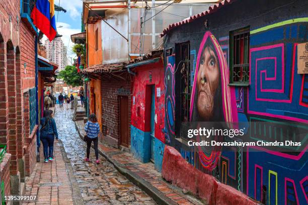 bogotá, colombia - local colombians walk down the narrow, cobblestoned calle del embudo in the historic la candelaria district of the andes capital city - plaza del chorro de quevedo stock pictures, royalty-free photos & images