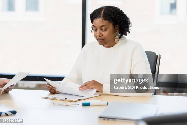 serious mature female manager analyzes documents during meeting - lawyers serious stock pictures, royalty-free photos & images