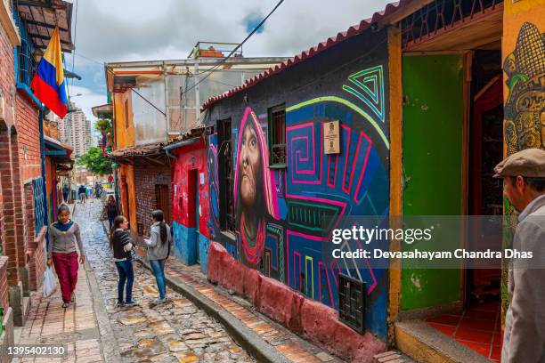 bogotá, colombia - local colombians walk down the narrow, cobblestoned calle del embudo in the historic la candelaria district of the andes capital city - plaza del chorro de quevedo stock pictures, royalty-free photos & images