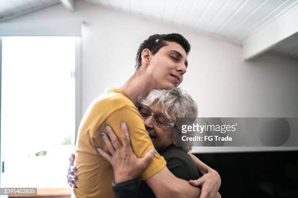 großmutter umarmt enkel zu hause - grateful stock-fotos und bilder