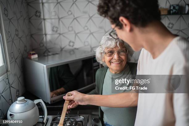 grandson and grandmother cooking at home - grandson stock pictures, royalty-free photos & images